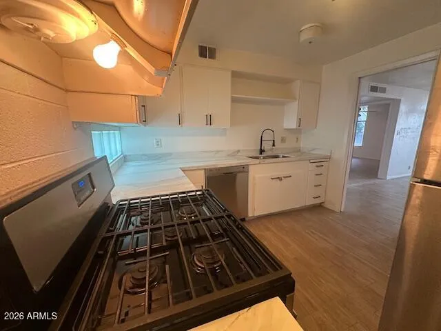 a kitchen with granite countertop a stove and cabinets