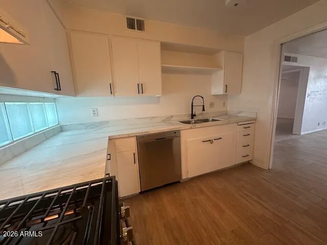 a kitchen with a sink cabinets and wooden floor