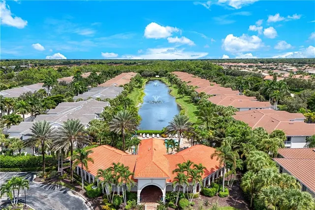 an aerial view of ocean and residential houses with outdoor space