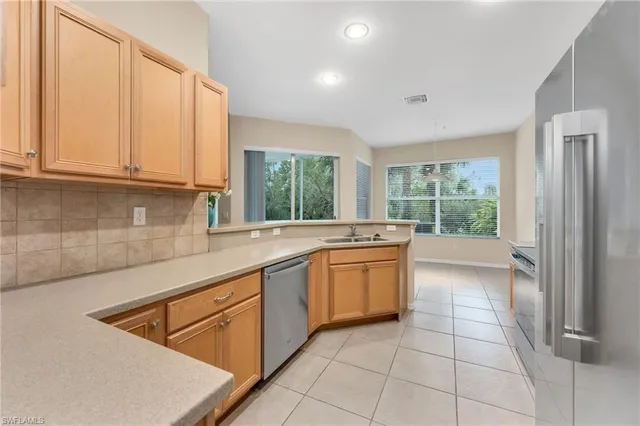 a large kitchen with kitchen island granite countertop a large window and a sink