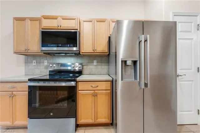 a kitchen with stainless steel appliances a stove a refrigerator and a microwave
