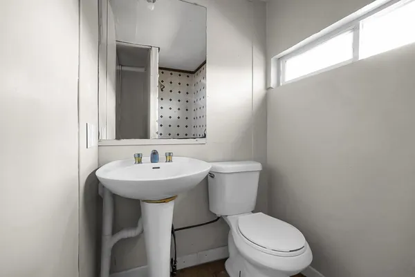 a bathroom with a toilet a sink and a window