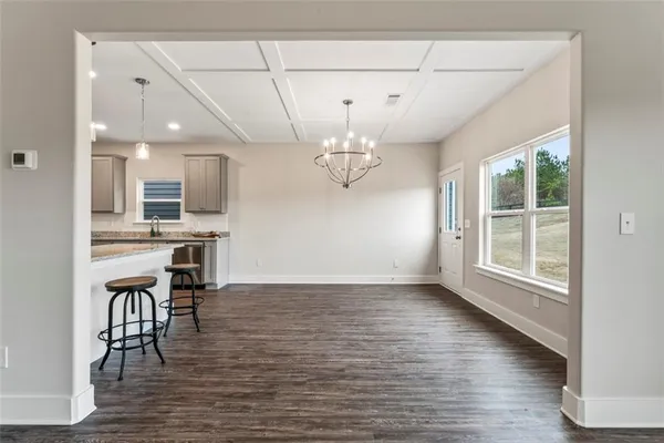 a view of a dining room with furniture a chandelier and wooden floor