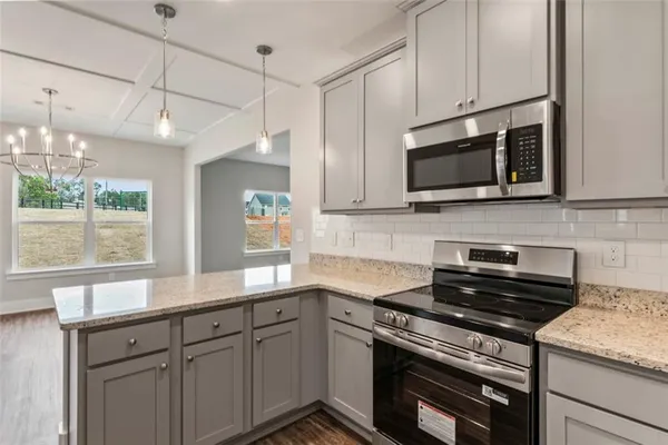 a kitchen with granite countertop cabinets stainless steel appliances and window
