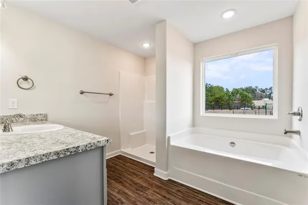a bathroom with a granite countertop sink and a bathtub