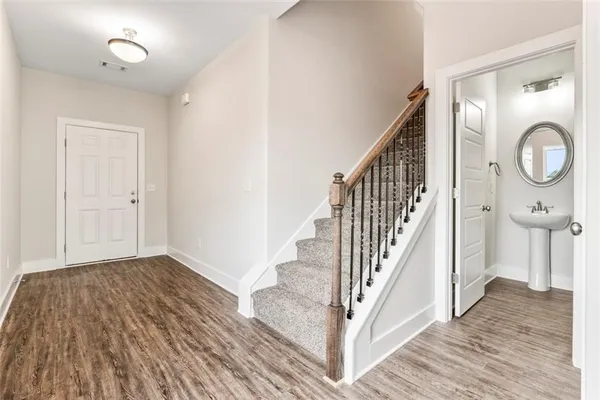 a view of a hallway with wooden floor and staircase