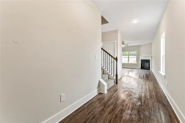 a view of a hallway with wooden floor and staircase