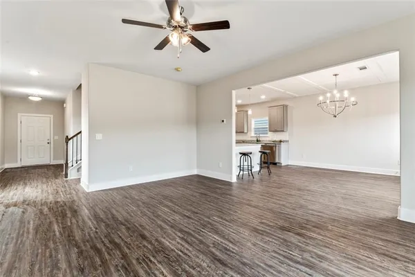 a view of empty room with wooden floor and ceiling fan