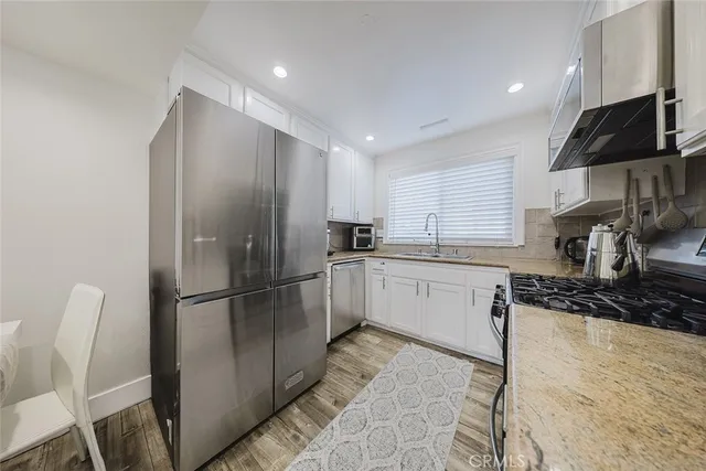 a kitchen with a refrigerator and a stove top oven