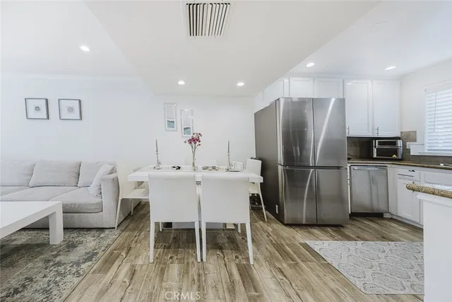 a kitchen with stainless steel appliances a refrigerator and a stove top oven