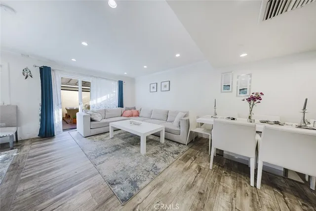 a living room with furniture a wooden floor and next to a window