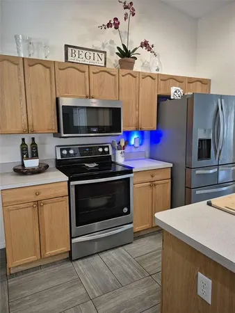a kitchen with stainless steel appliances a stove microwave and refrigerator