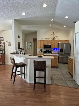 a kitchen with stainless steel appliances kitchen island granite countertop a refrigerator and a stove top oven