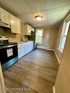 383 Old Rte 940, Unit 302 Pocono Pines, PA 18350 - Photo 2 of 5 a large kitchen with stainless steel appliances granite countertop a stove a sink and a white cabinets