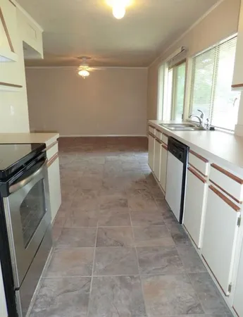 a view of a kitchen with a sink dishwasher and a fireplace