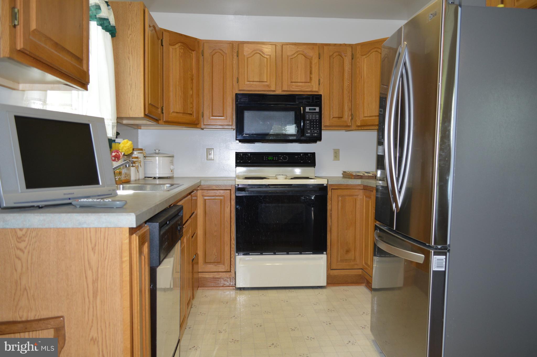 2124 Poplar Road Baltimore, MD 21221 - Photo 21 of 29 a kitchen with stainless steel appliances a stove a microwave a refrigerator a sink and cabinets