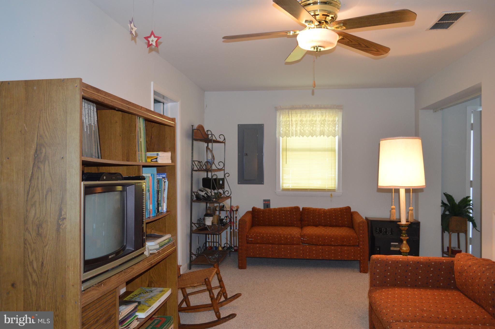 2124 Poplar Road Baltimore, MD 21221 - Photo 24 of 29 a living room with furniture a chandelier and a flat screen tv