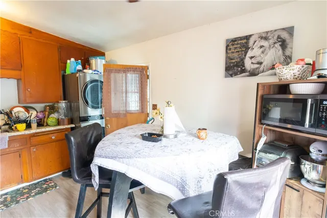 a kitchen with stainless steel appliances granite countertop a refrigerator a microwave a stove and a dining table