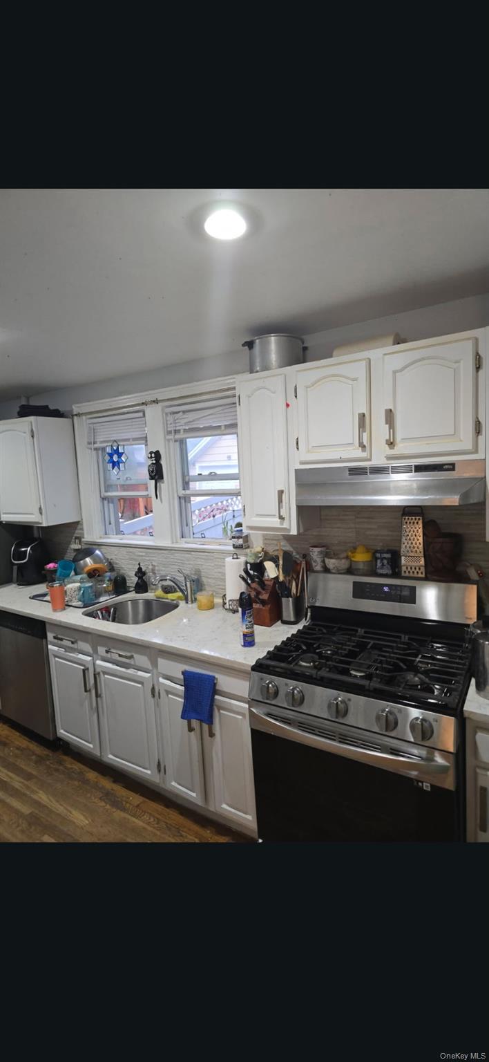 4425 Edson Avenue Bronx, NY 10466 - Photo 12 of 21 a kitchen with stainless steel appliances a stove a sink and white cabinets