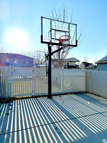 36 North Trailside Road West Farmington, UT 84025 - Photo 13 of 15 Spacious recreational court featuring a professional-grade basketball hoop with tempered glass backboard and red rim, positioned on a composite decking surface with linear striping