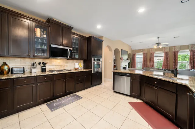 a large kitchen with stainless steel appliances kitchen island granite countertop a sink and cabinets