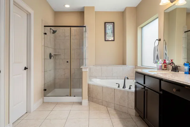 a bathroom with a bathtub a shower a sink and a mirror