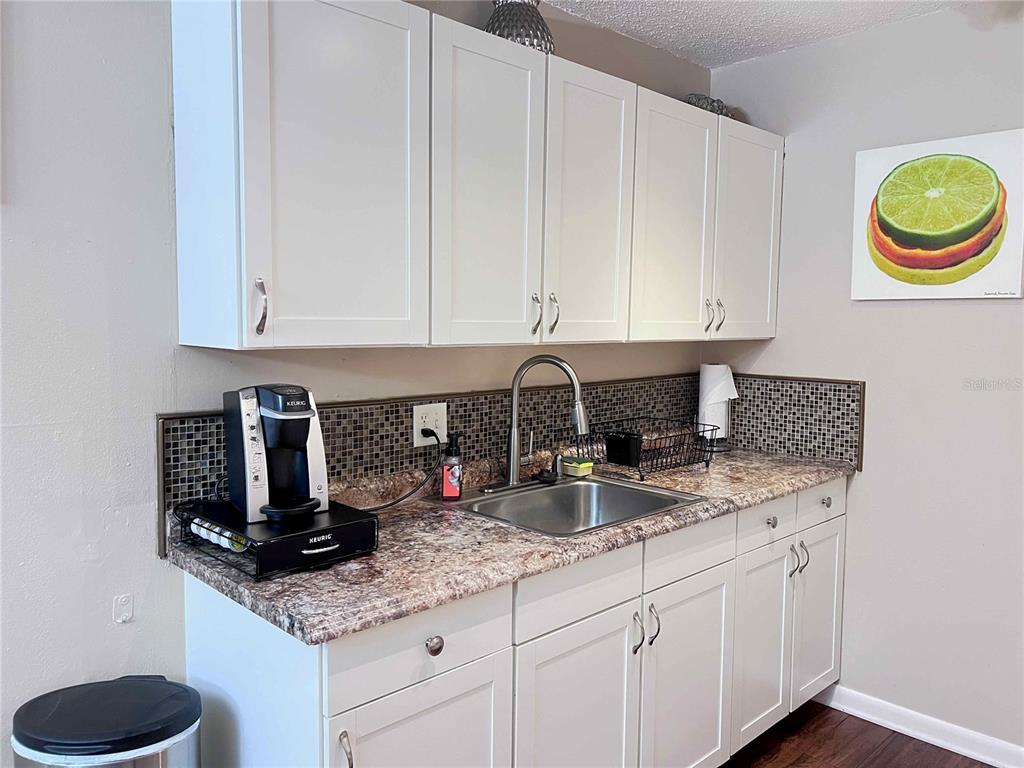1700 Southwest 16th Court, Unit C26 Gainesville, FL 32608 - Photo 3 of 18 a kitchen with granite countertop a sink a stove and cabinets