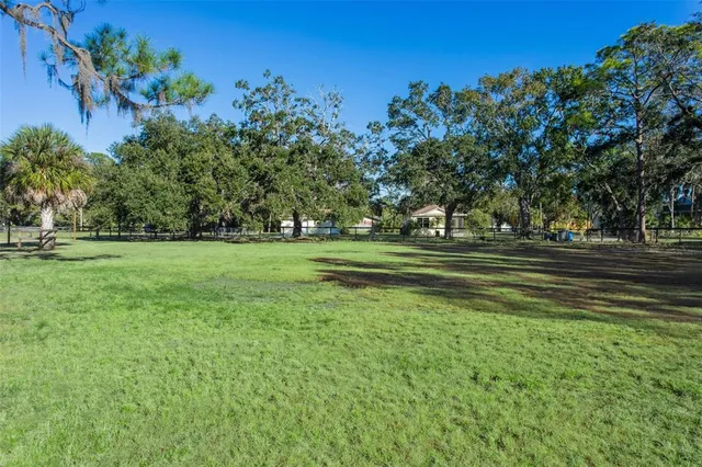 a backyard of a house with lots of green space and outdoor seating