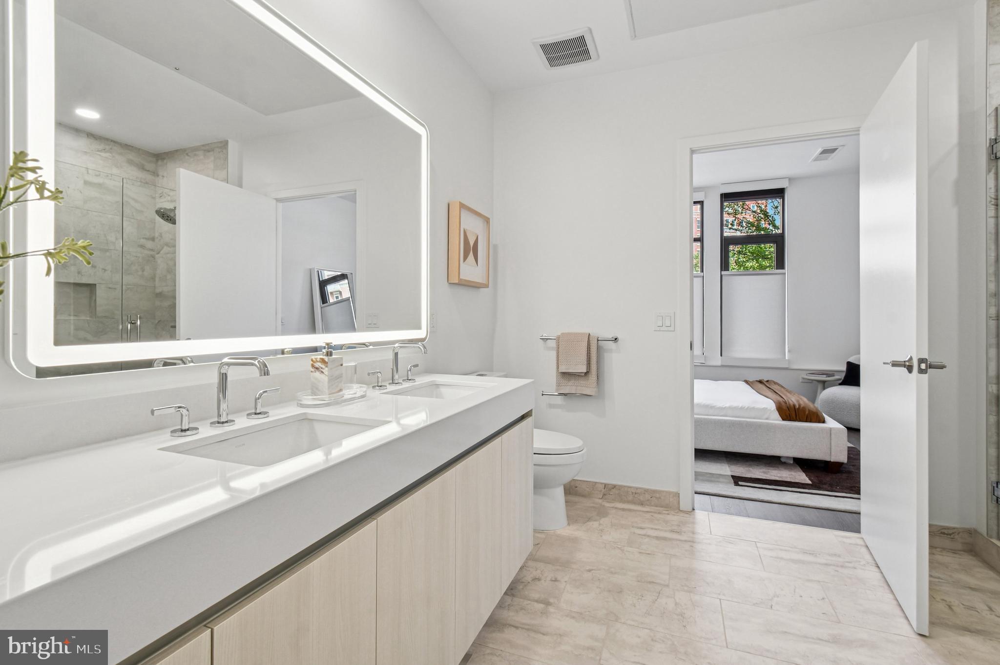 2650 Woodley Road Northwest, Unit 621 Washington, DC 20008 - Photo 9 of 36 a en suite bathroom with a granite countertop sink and a mirror