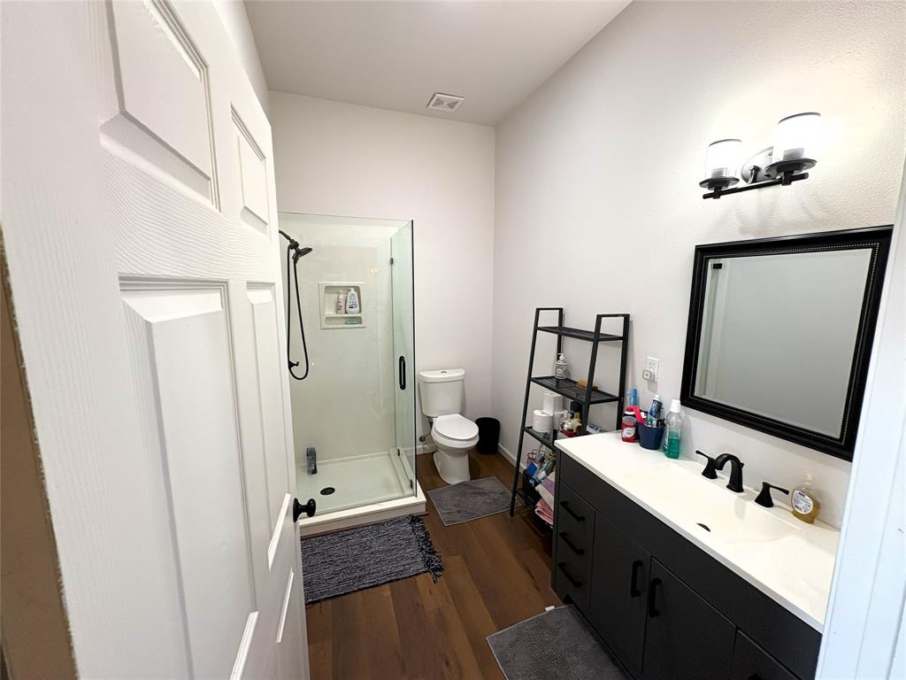 4748 Battle Lake Road Mart, TX 76664 - Photo 10 of 33 Full bath with wood finished floors, toilet, a stall shower, and vanity