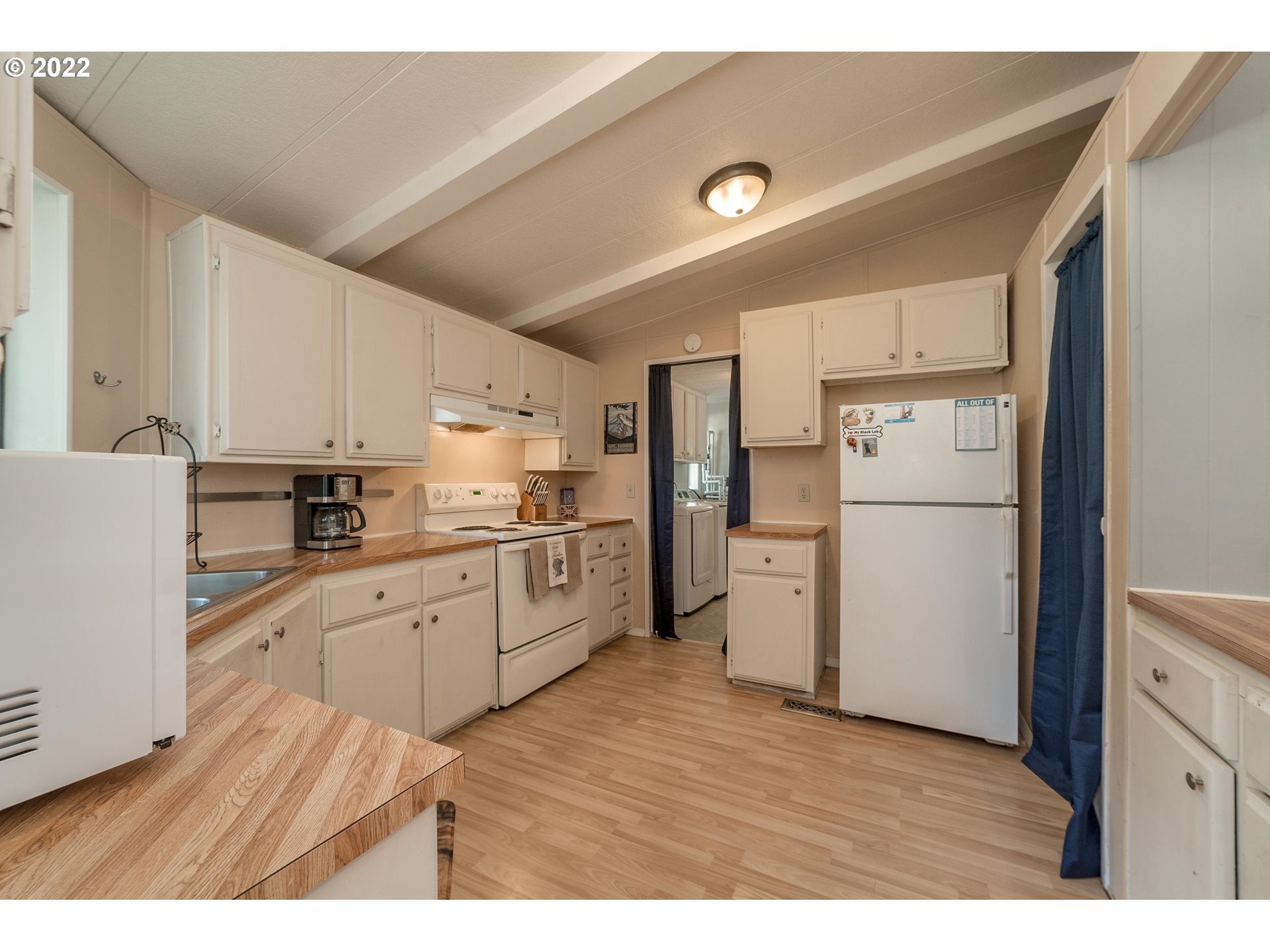 5816 Northwest 304th Street Ridgefield, WA 98642 - Photo 8 of 26 a kitchen with a refrigerator a stove top oven and white cabinets