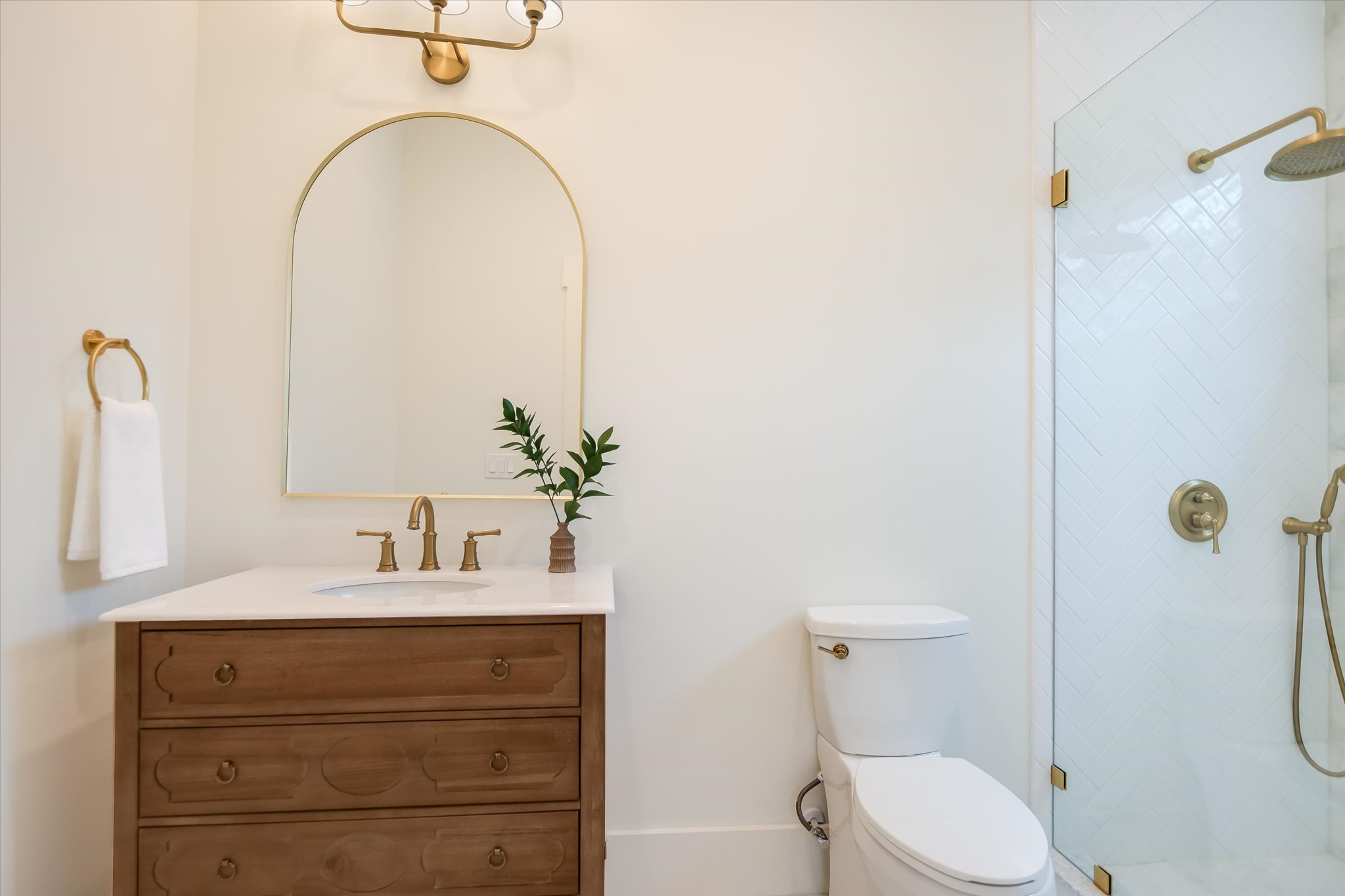 1210 Alguno Road Austin, TX 78757 - Photo 19 of 28 Just off the main-level bedroom, this full bath is finished with clean lines, warm wood tones, and a beautifully tiled walk-in shower.