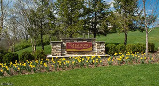 a sign that is sitting in front of flowers