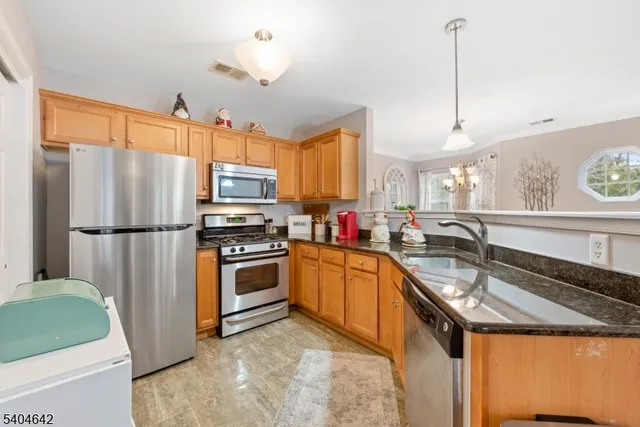 a kitchen with granite countertop a sink stainless steel appliances and a counter top space