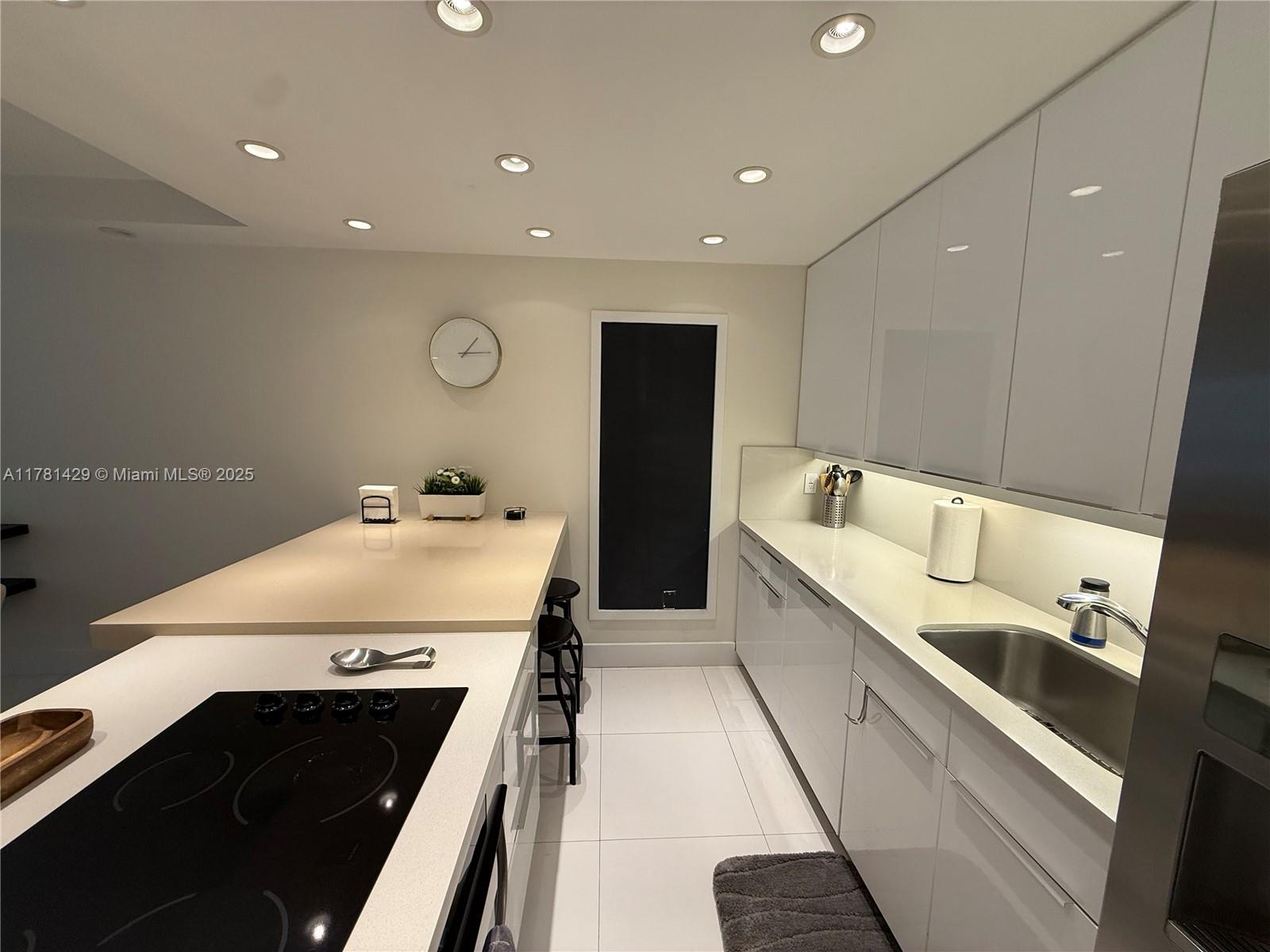 161 Crandon Boulevard, Unit 221 Key Biscayne, FL 33149 - Photo 11 of 13 a large white kitchen with a stove and a refrigerator