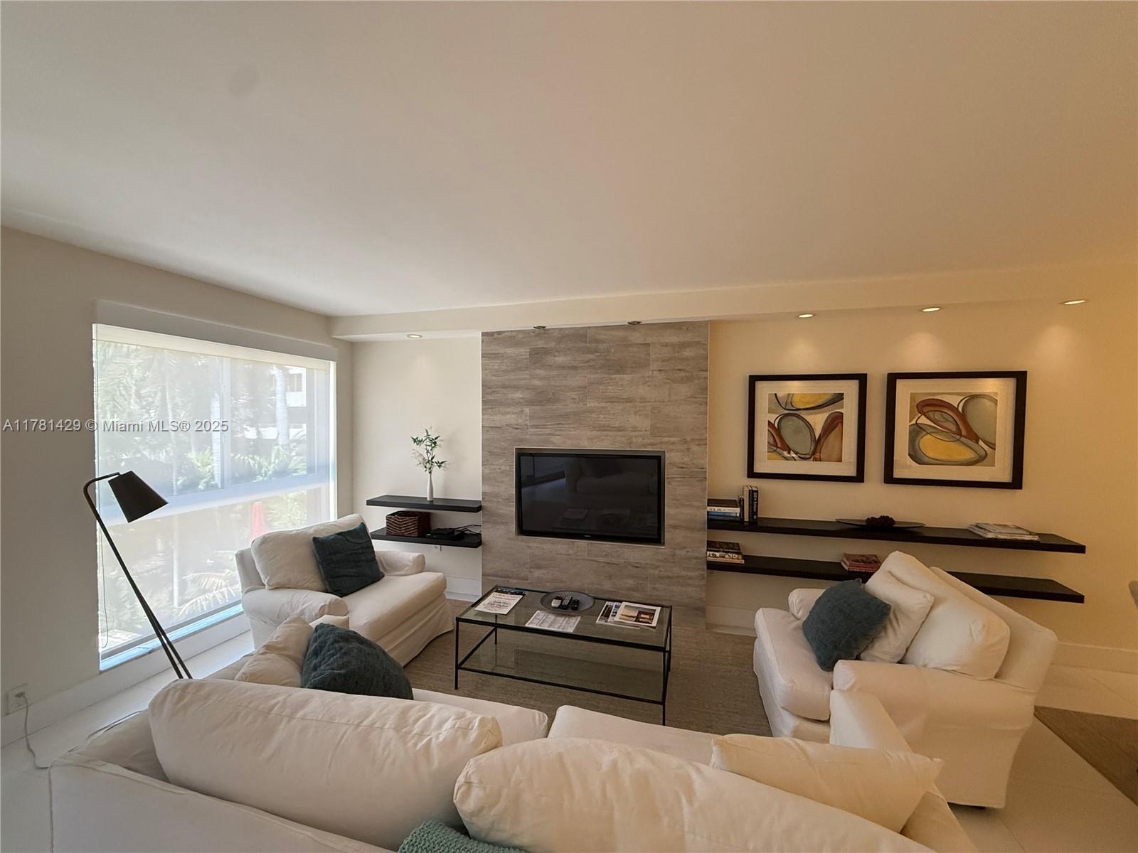 161 Crandon Boulevard, Unit 221 Key Biscayne, FL 33149 - Photo 12 of 13 a living room with furniture and a fireplace