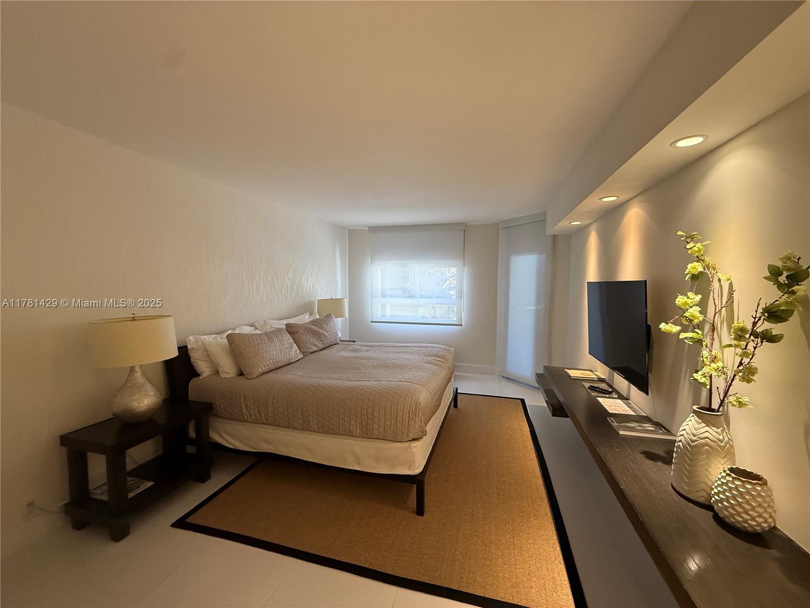 161 Crandon Boulevard, Unit 221 Key Biscayne, FL 33149 - Photo 6 of 13 a bedroom with a bed window and flat screen tv