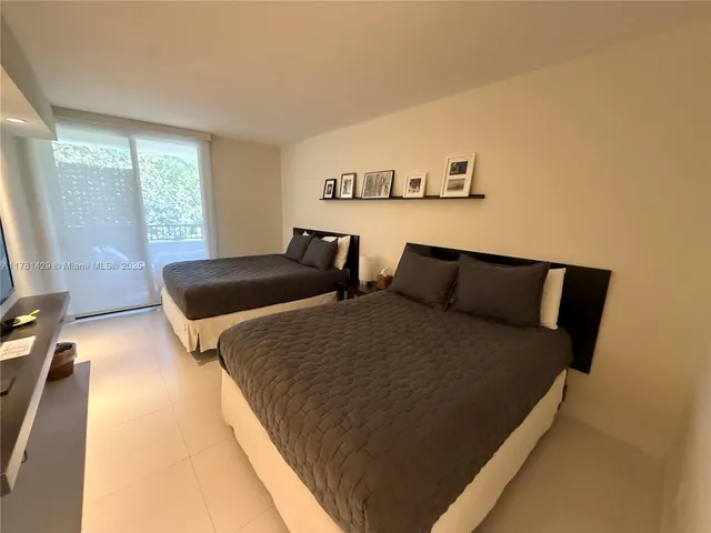 a bed sitting in a bedroom next to a window with lamp