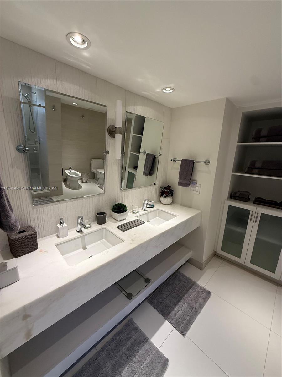 161 Crandon Boulevard, Unit 221 Key Biscayne, FL 33149 - Photo 9 of 13 a bathroom with a double vanity sink and mirror