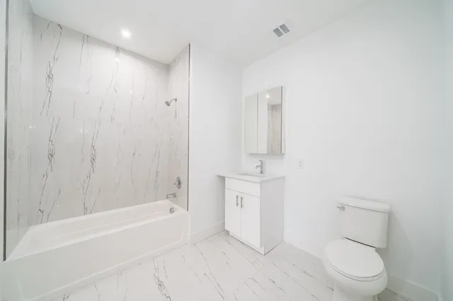 a spacious bathroom with a sink a toilet and shower