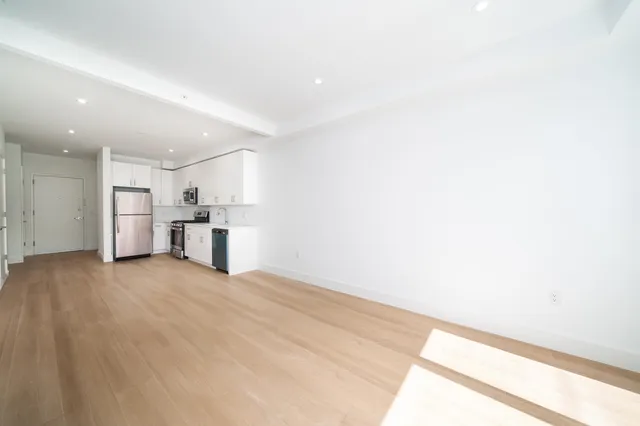 a view of empty room with kitchen