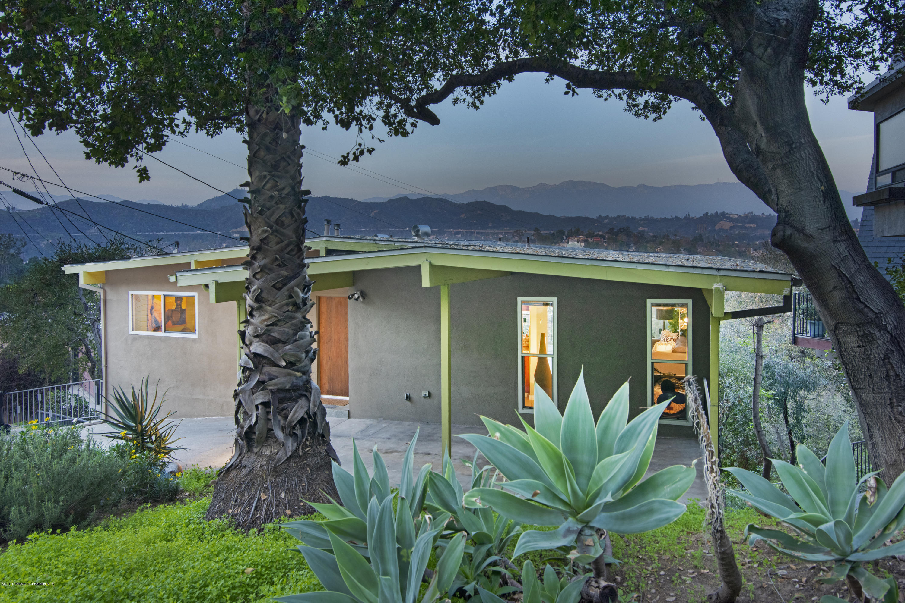 a front view of a house with a tree