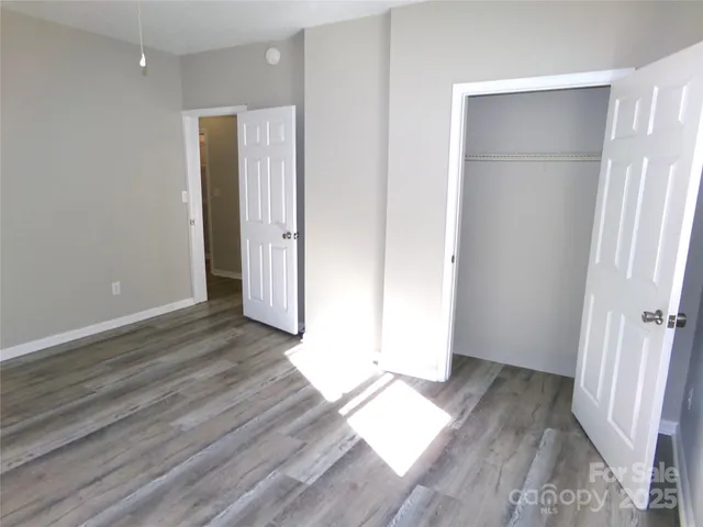 an empty room with wooden floor and entrance