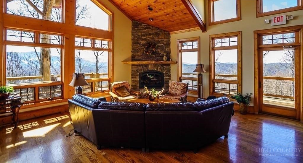 485 Woodlake Loop Road Elk Park, NC 28622 - Photo 39 of 44 a living room with fireplace furniture and floor to ceiling windows