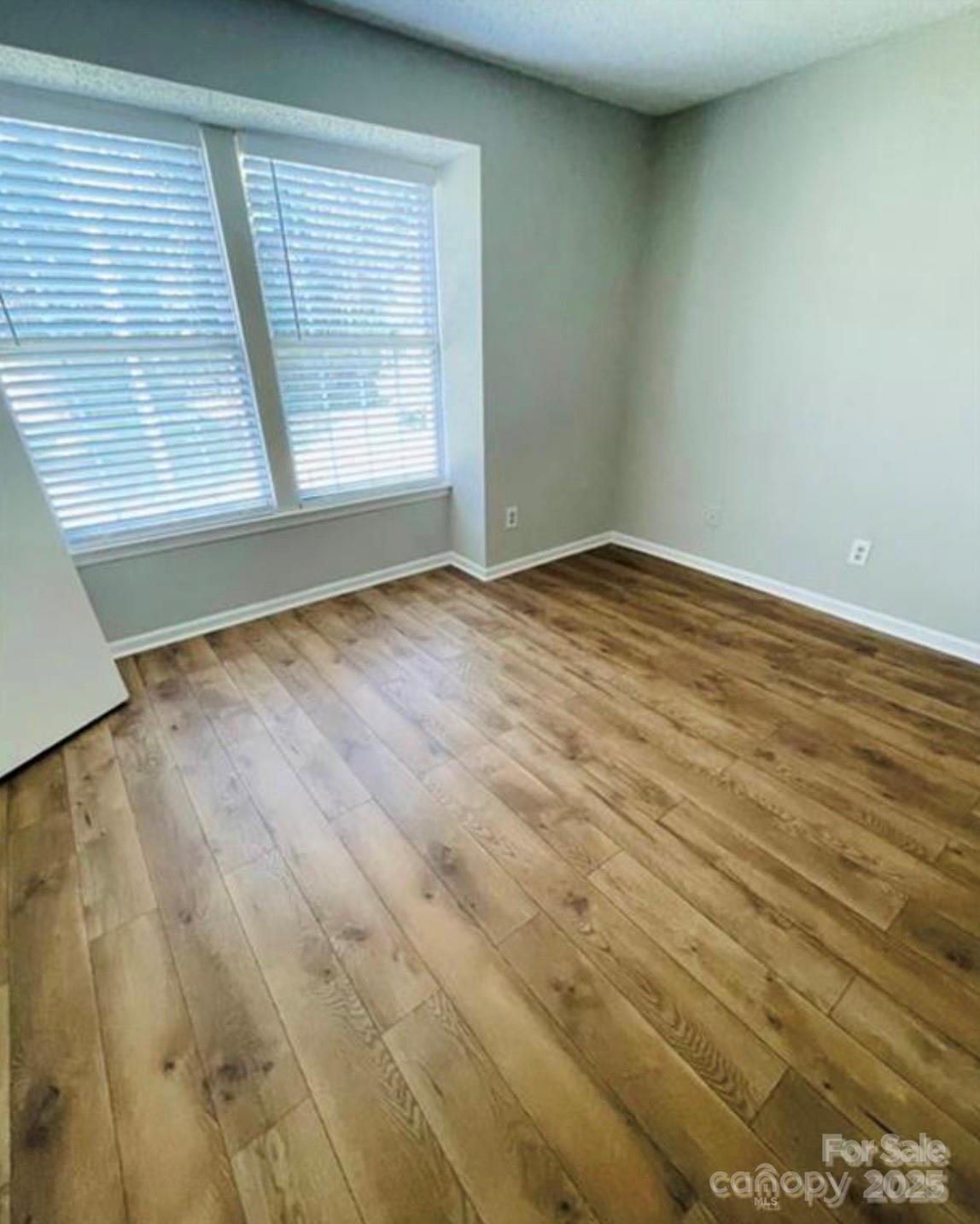 1624 Arlyn Circle, Unit G Charlotte, NC 28213 - Photo 12 of 13 an empty room with wooden floor and windows