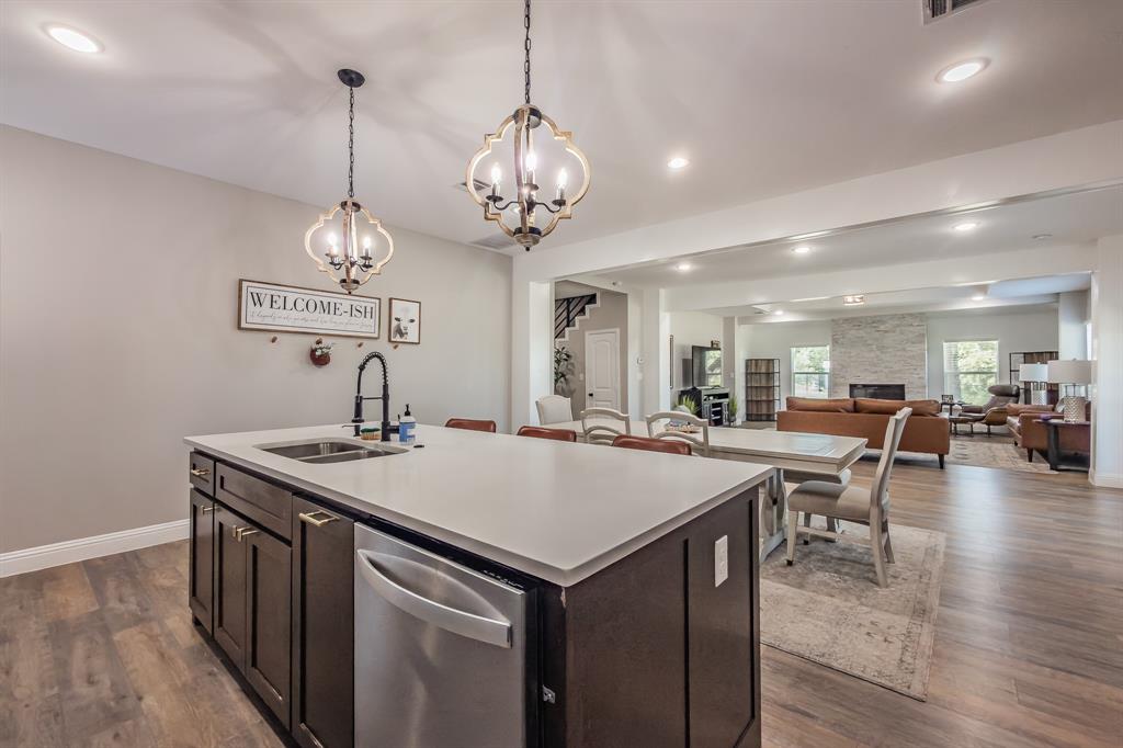 117 Rock Salt Drive Springtown, TX 76082 - Photo 7 of 38 Kitchen island with a double basin sink, stainless steel dishwasher, and a light-toned countertop