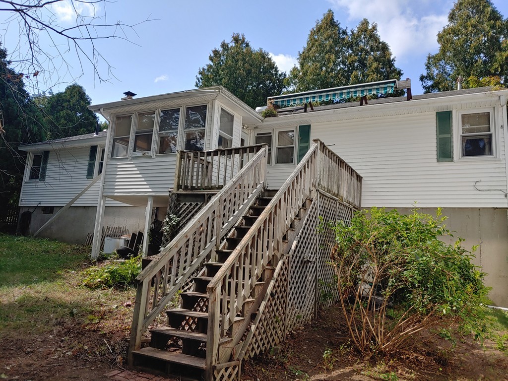 a view of a house with wooden stairs and a small yard