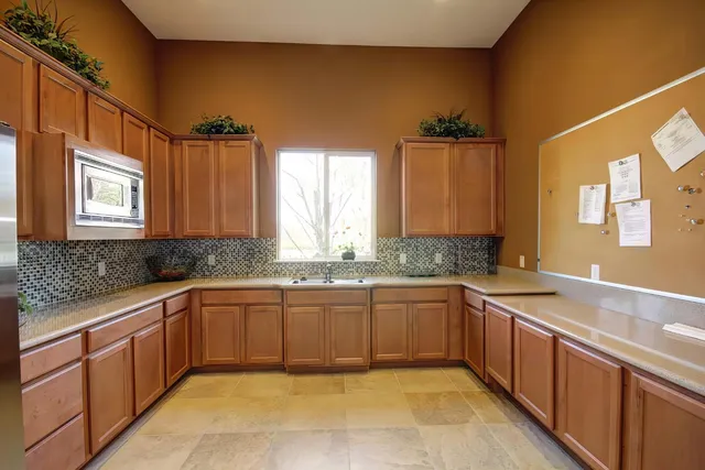 a large kitchen with stainless steel appliances granite countertop a sink and dishwasher cabinets with wooden floor