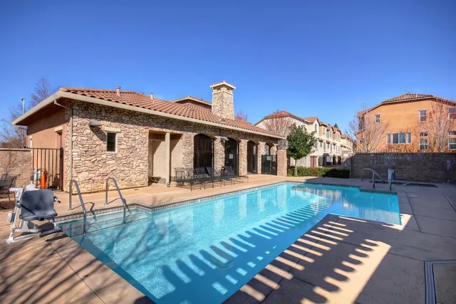 a view of a house with pool and sitting area