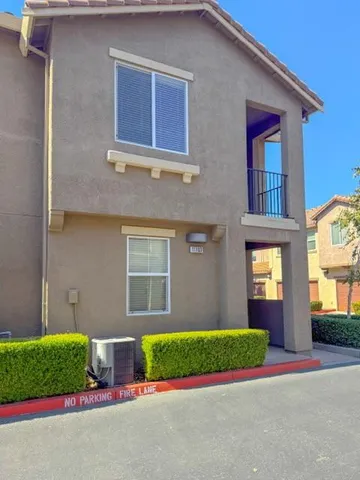 a brick house with a large windows wooden fence
